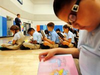 00023955A ma nb AlmadelMar1stDay  K-4th graders read a book while sitting in the gymnasium as they prepare for morning routine on the first day of school at the Alma del Mar's new school on Belleville Avenue in the north end of New Bedford.   PETER PEREIRA/THE STANDARD-TIMES/SCMG : school, education